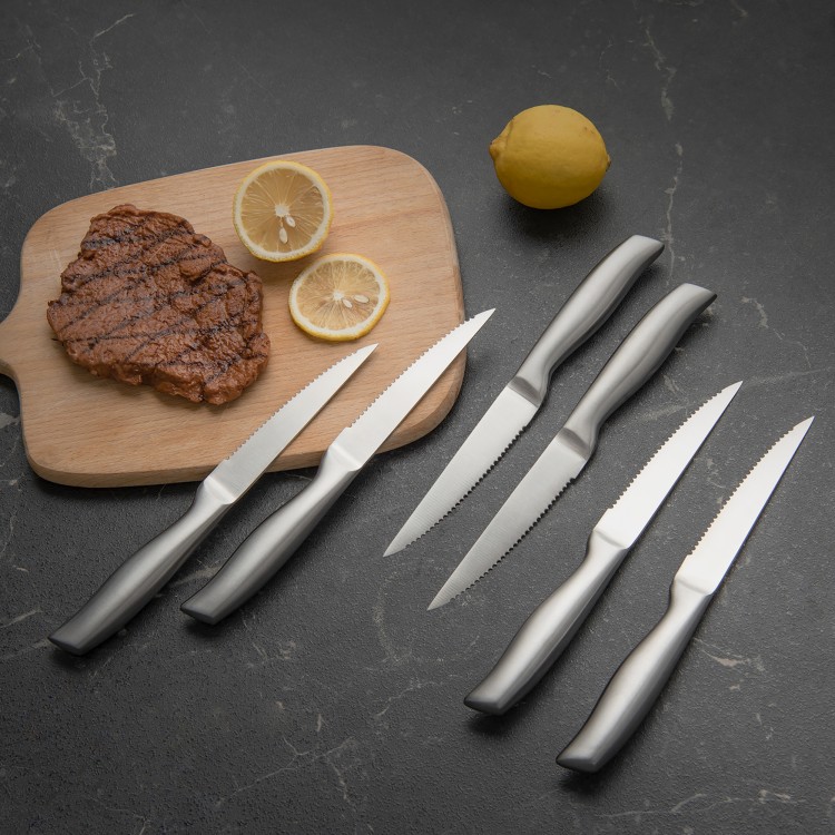 14-piece stainless steel kitchen knife set displayed on a cutting board with steak and lemon, featuring ergonomic.