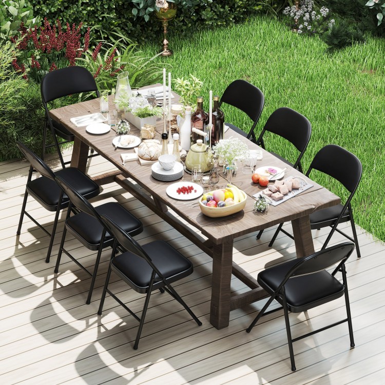 Black folding chairs with metal frame and PVC leather, set up for an outdoor dining scene on a wooden deck.
