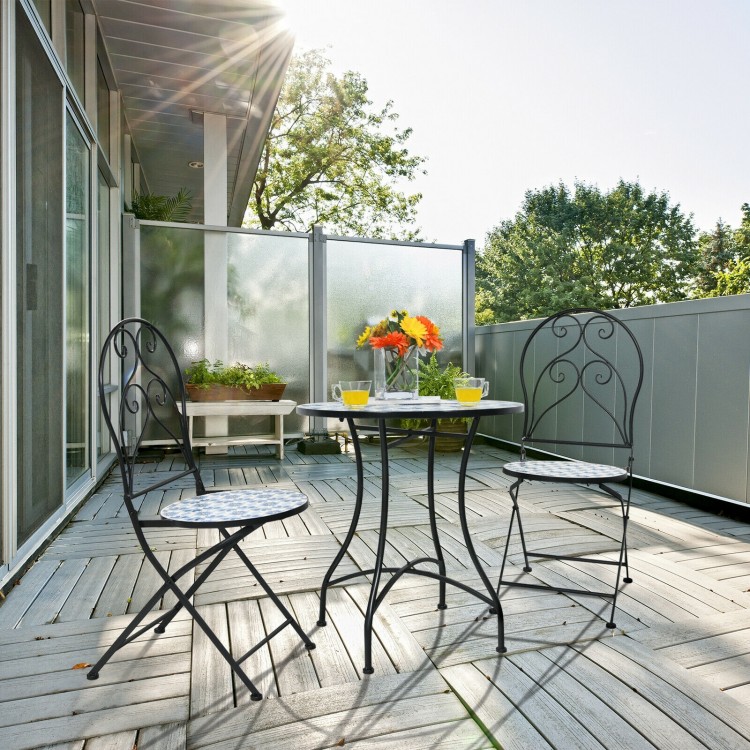 Two folding bistro chairs with blue floral mosaic pattern on a patio, perfect for outdoor relaxation and dining.