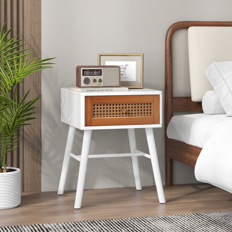 Mid-century modern rattan nightstand with white finish, spacious tabletop, and pull-out drawer for stylish storage.
