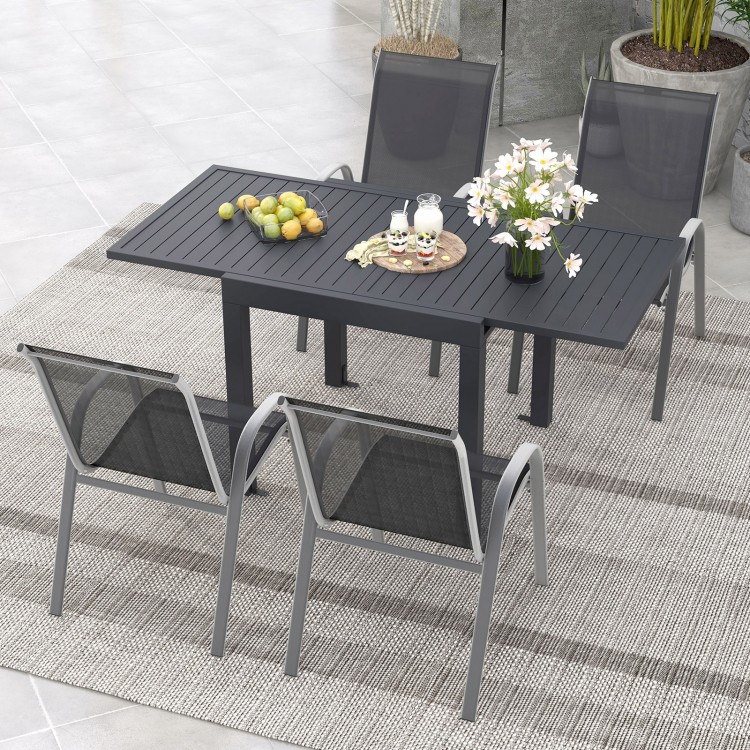 Outdoor dining table set featuring an extendable aluminum table and 4 stackable chairs, perfect for backyard meals.