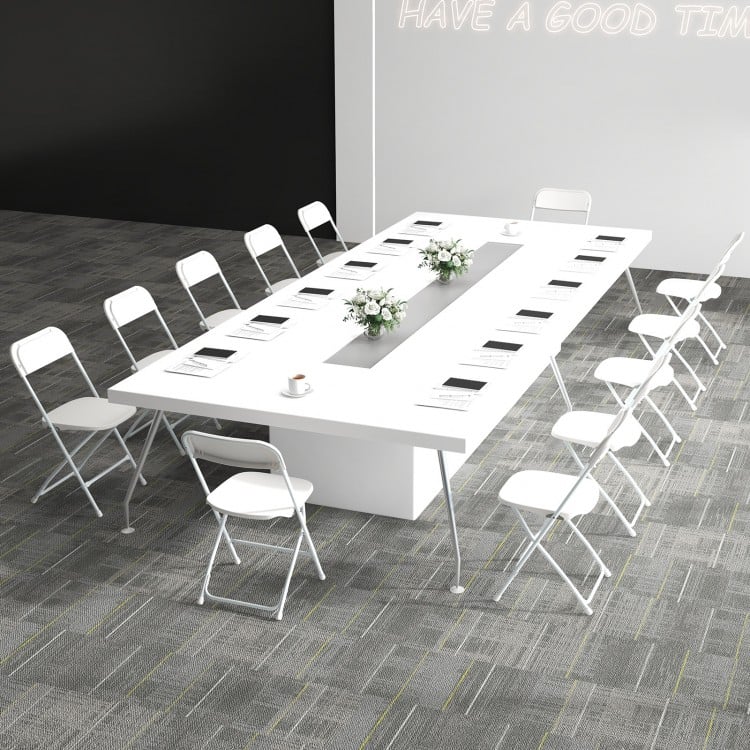 White metal folding chairs arranged around a large conference table, ideal for office meetings and events.
