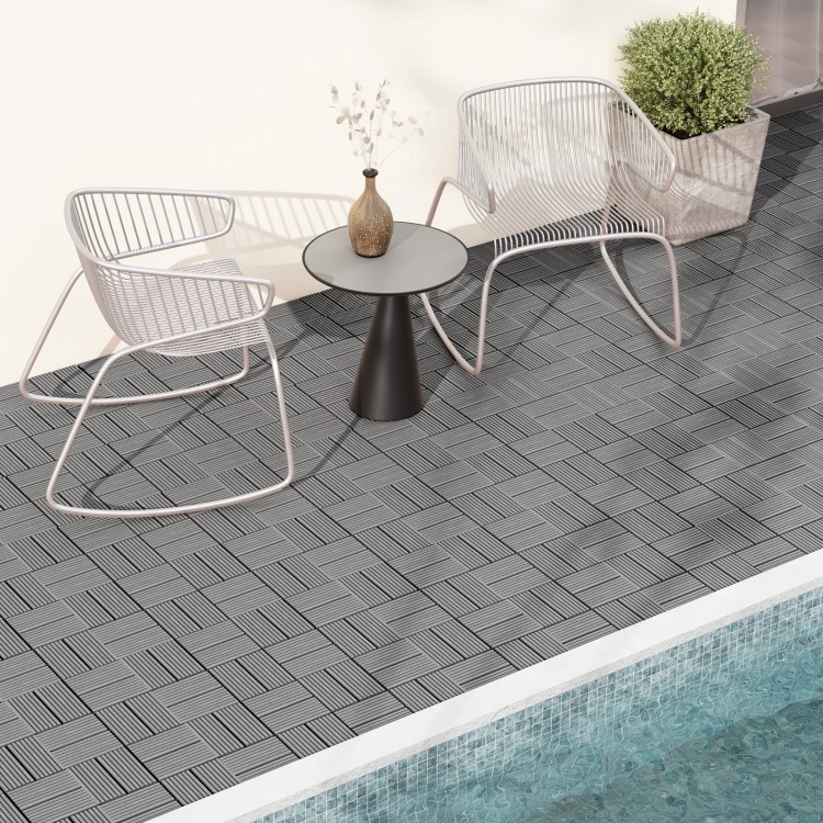 Gray interlocking deck tiles arranged on a patio, showcasing a slatted design for outdoor elegance and drainage.