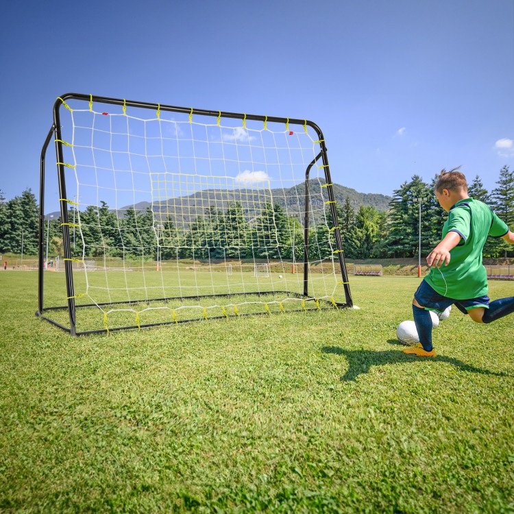 Kids soccer player kicking a ball towards the adjustable 2-in-1 soccer goal and rebounder on a grassy field.