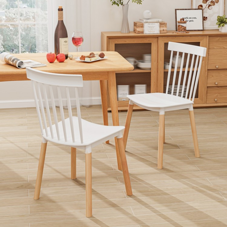 Windsor dining chairs with spindle backs and curved seats in white, featuring a sturdy beech wood frame for comfort.