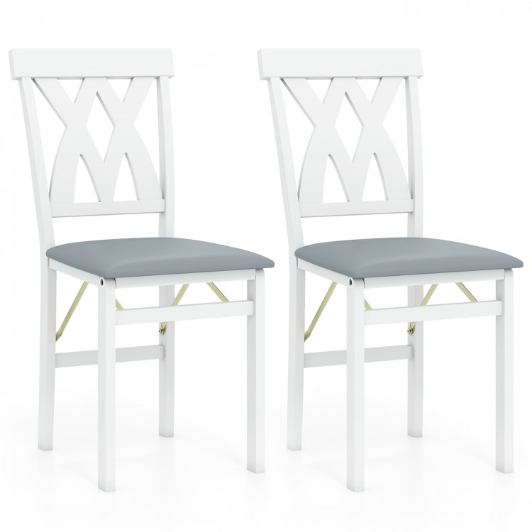 Set of 2 white folding wooden dining chairs with gray faux leather seats and X-shaped backrests, ideal for small spaces.