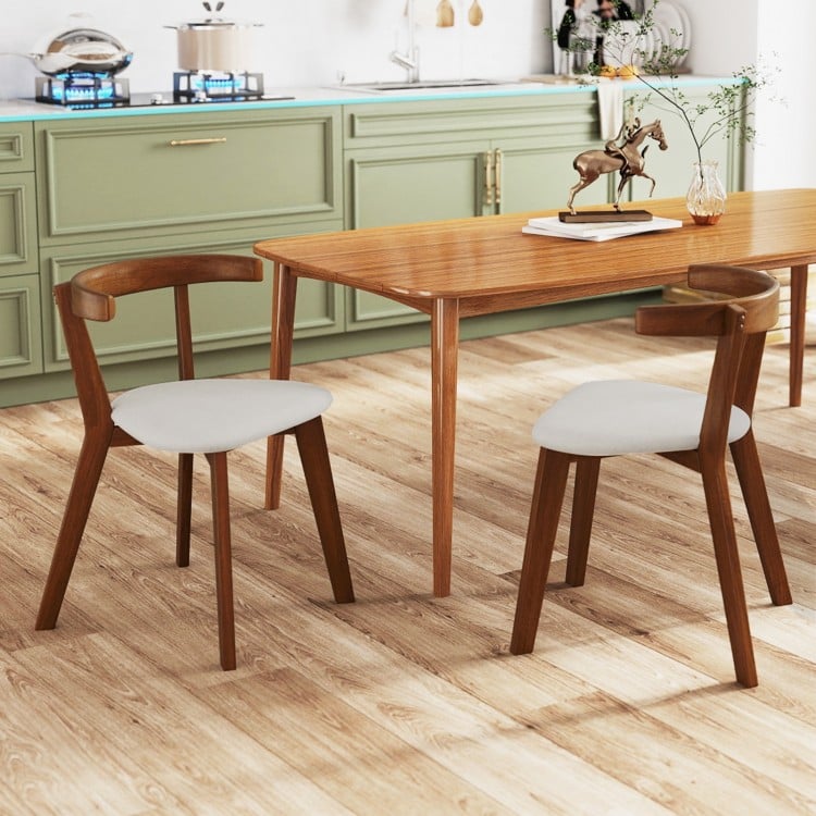 Wood dining chair set of 2 with padded seats and curved backs in walnut finish, ideal for dining rooms or kitchens.