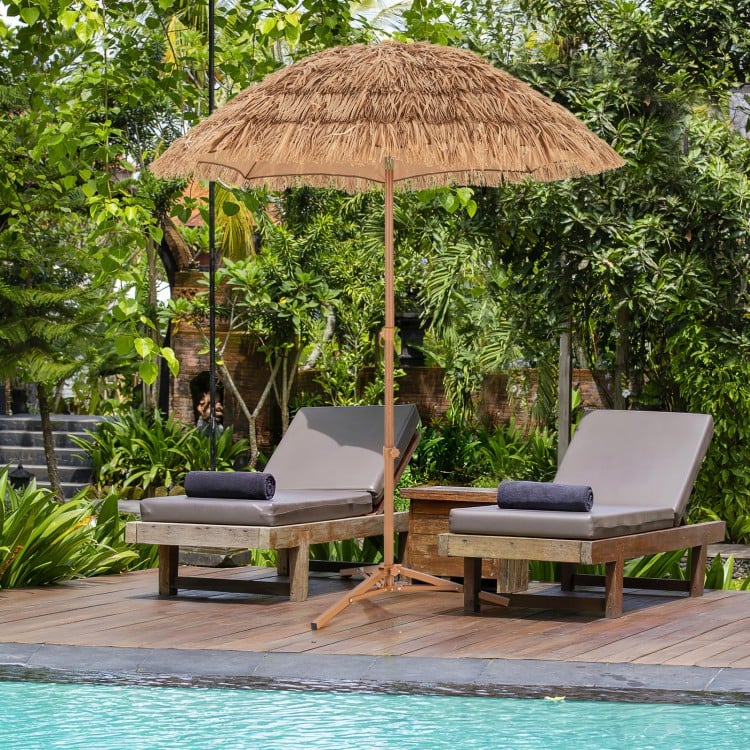 Thatched tiki umbrella with foldable stand, made of polyester and PP, providing sun protection for outdoor relaxation.