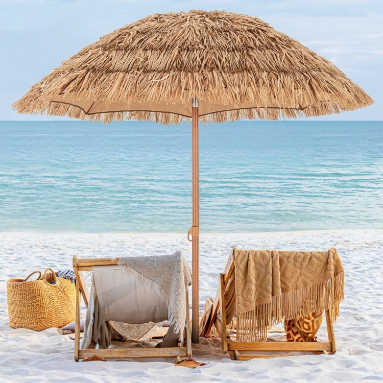 Thatched tiki umbrella with foldable stand, made of polyester and PP thatch, providing sun protection for beach.