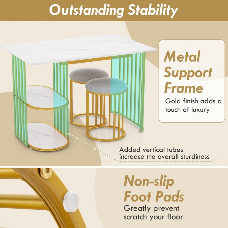 Rectangular dining table with gold metal frame, faux marble surface, and two upholstered stools for small space dining.