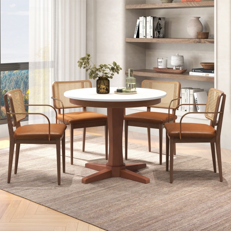 Round dining table with pedestal base in cream white and walnut finishes, perfect for gatherings and easy to clean.
