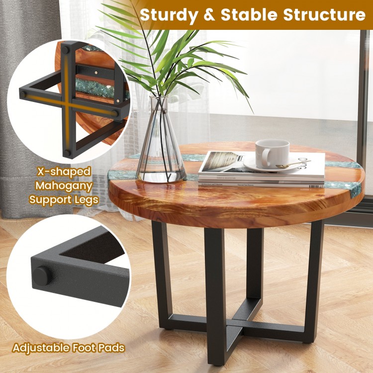 Solid live edge round teak wood end table with epoxy resin, showcasing X-shaped legs and adjustable foot pads for.