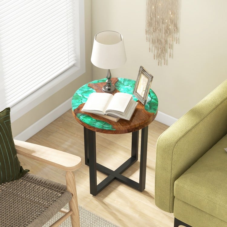 Round teak wood end table with epoxy resin top, featuring X-shaped legs, perfect for outdoor use on patios or balconies.