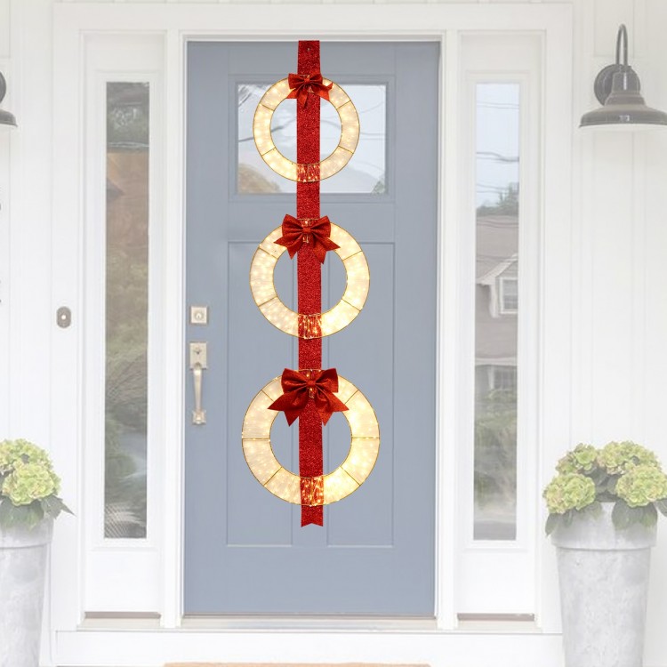 Set of 3 lighted metal wreaths with warm white LED lights and bows, hanging on a red ribbon for festive outdoor decor.