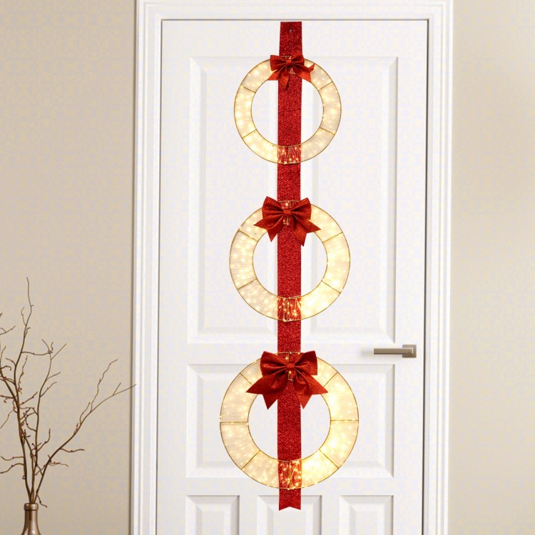 Set of 3 lighted Christmas wreaths with warm white LED lights and bows, hung on a red ribbon for festive decoration.