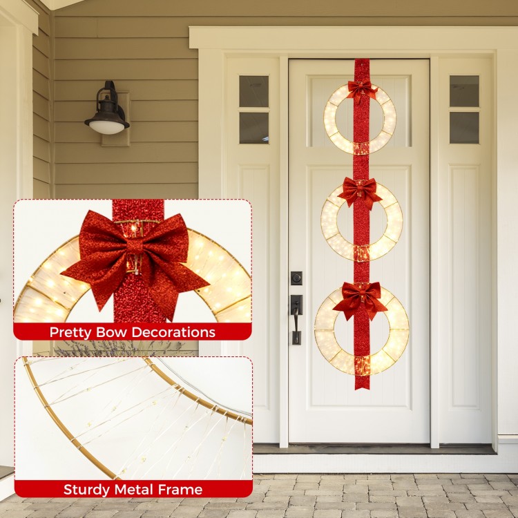 Set of 3 Christmas lighted wreaths with warm white LED lights and bows, perfect for festive doorway decoration.