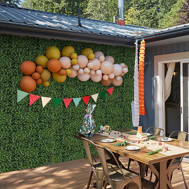 Artificial topiary gardenia shrub grass panels displayed on a wall, perfect for indoor or outdoor party decorations.