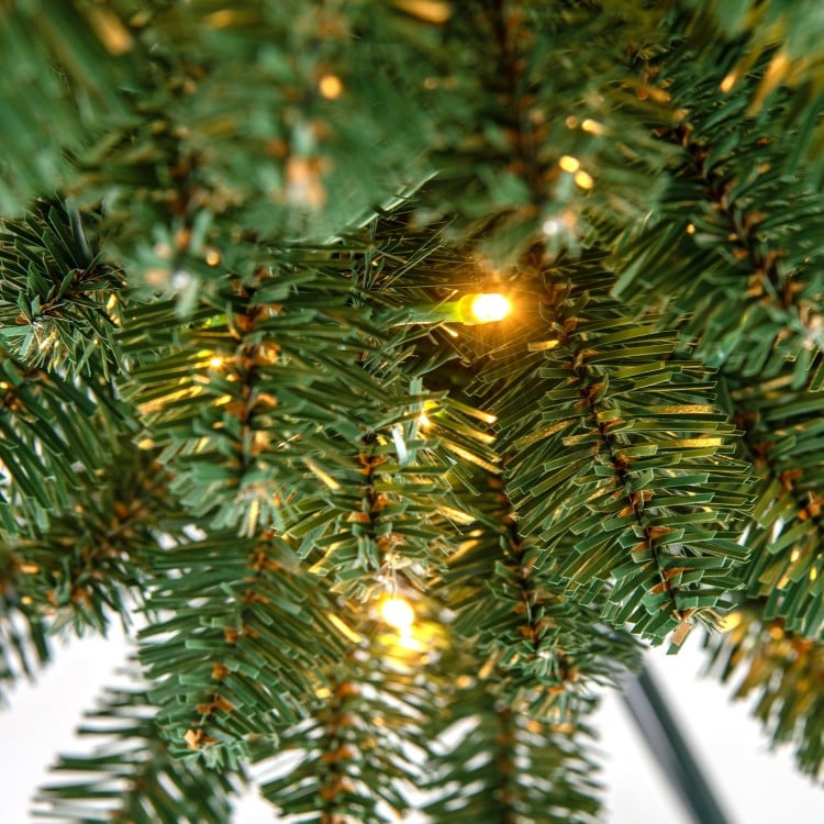 Close-up of the Pencil Christmas Tree's lush green branch tips with warm LED lights, perfect for festive decorations.