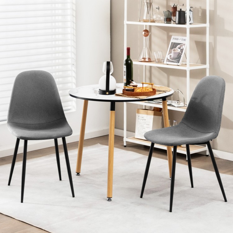 Gray dining chairs with black metal legs, featuring foam upholstery and ergonomic backrest, ideal for dining rooms.