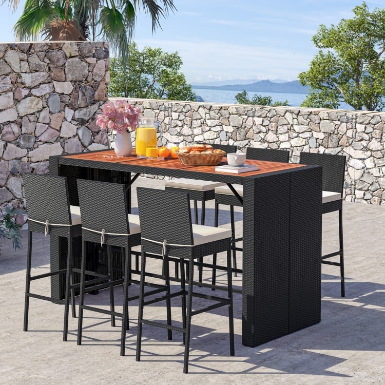 7-piece patio rattan bar set with acacia wood tabletop and soft cushions, perfect for outdoor gatherings in the garden.