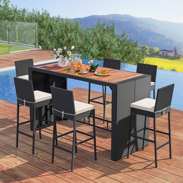 7-piece patio rattan bar set with acacia wood tabletop and soft cushions, ideal for outdoor gatherings by the poolside.