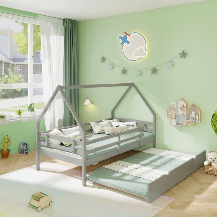 Twin house bed in gray with trundle, protective fence rail, and cozy bedding, perfect for a child's room.