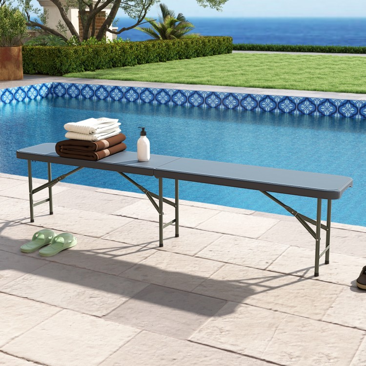Gray 6 feet plastic folding bench by the pool, featuring a heavy-duty frame, ideal for outdoor events and gatherings.