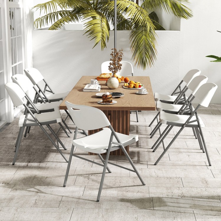 Set of four white folding stackable chairs with metal frame, perfect for outdoor dining and easy storage.