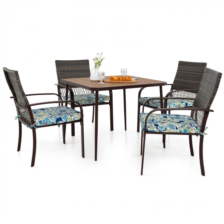 Square table with four cushioned rattan armchairs, perfect for outdoor dining in backyard or poolside settings.