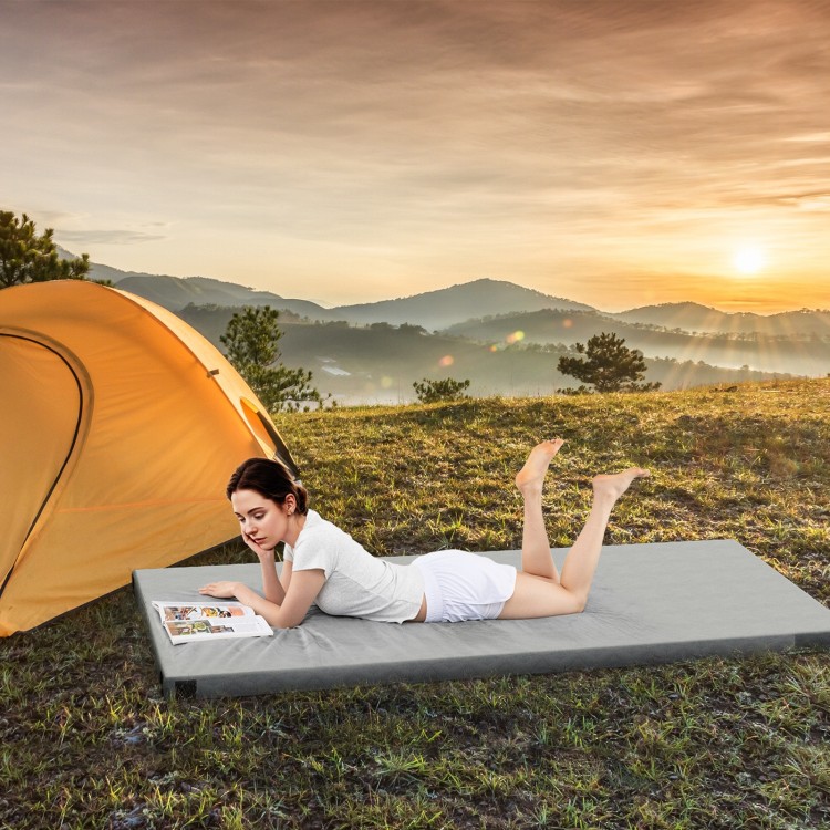 Foldable camping mattress in gray shown outdoors on grass, perfect for comfortable sleep while camping or picnicking.