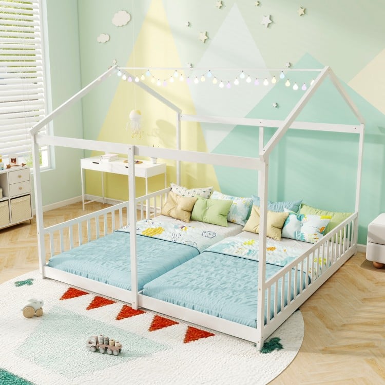 House-shaped double floor bed for twins in white with safety guardrails, ideal for shared sleeping spaces.