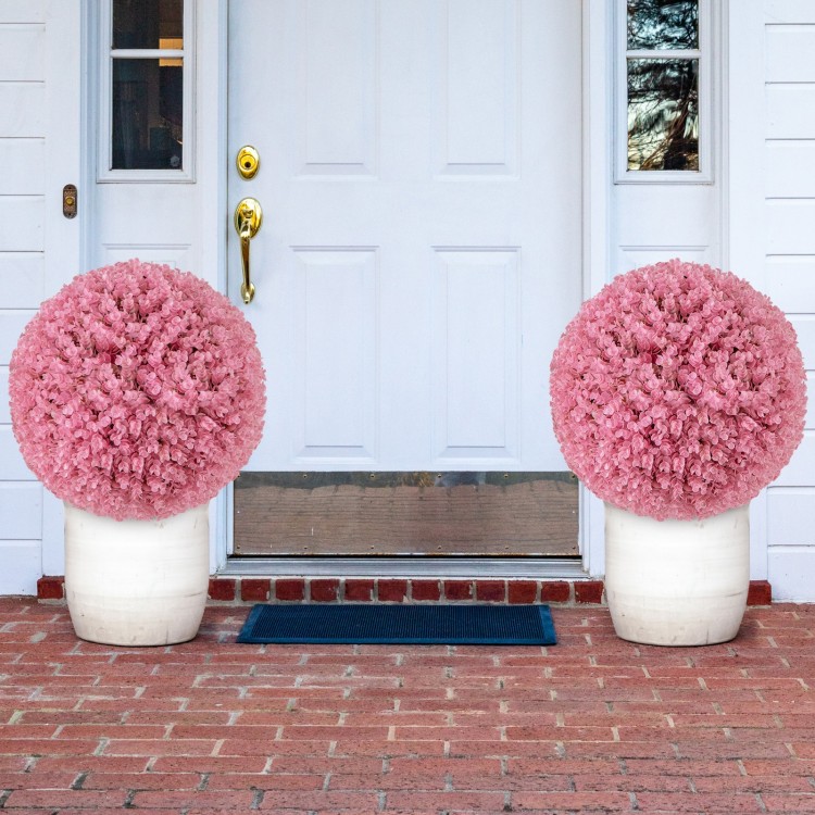 Two 17.5-inch faux pink eucalyptus decorative balls in white planters, perfect for garden or porch decoration.