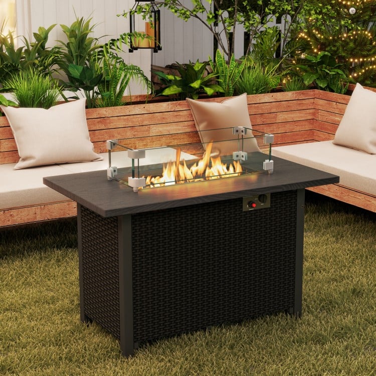 Black propane gas fire pit table with wind guard and glass rocks, designed for outdoor warmth and elegance.