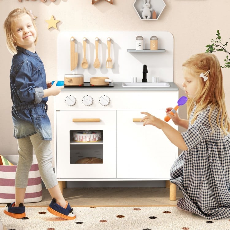 Kids kitchen playset in white with cooking accessories, featuring dual stoves, oven, and storage for imaginative play.
