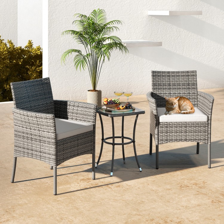 Two outdoor PE rattan armchairs with white cushions, perfect for patio relaxation and featuring a sturdy steel frame.
