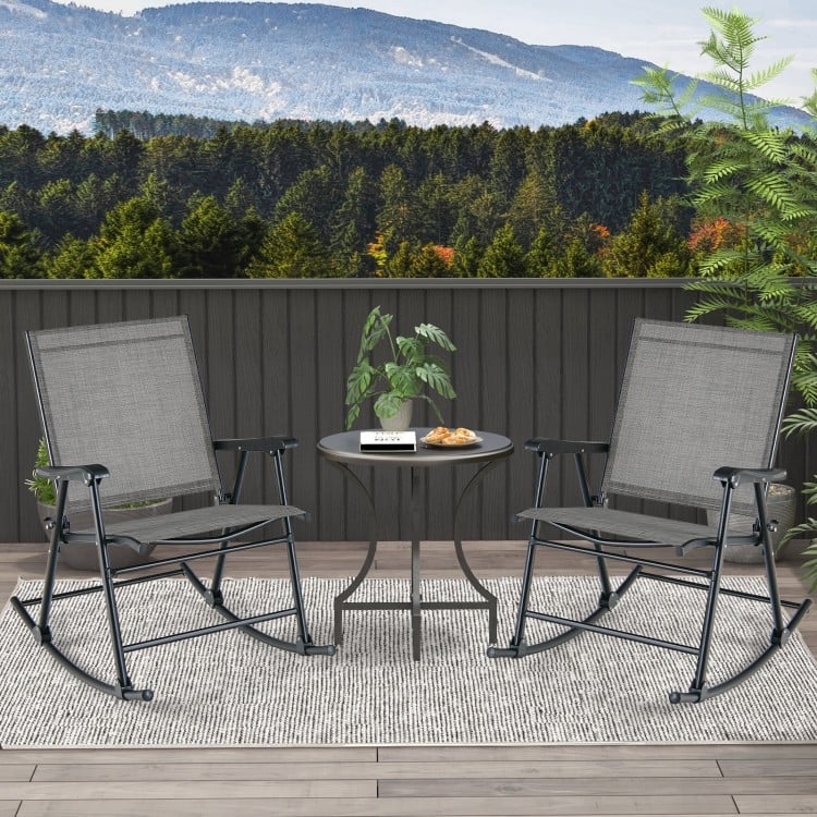Two gray folding rocking chairs with breathable fabric on a balcony, perfect for outdoor relaxation.