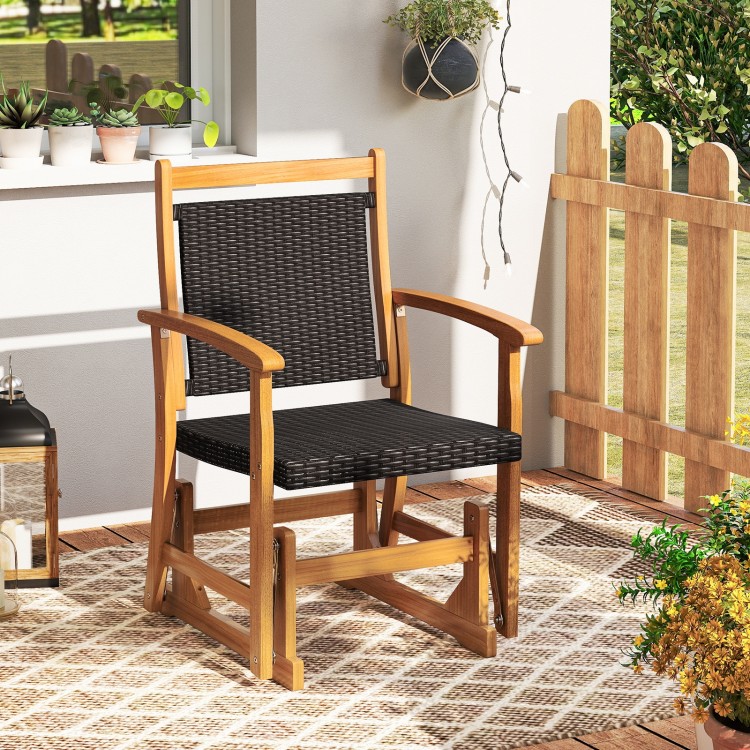 Patio rattan glider chair with acacia wood frame, featuring a wicker seat back, perfect for backyard relaxation.