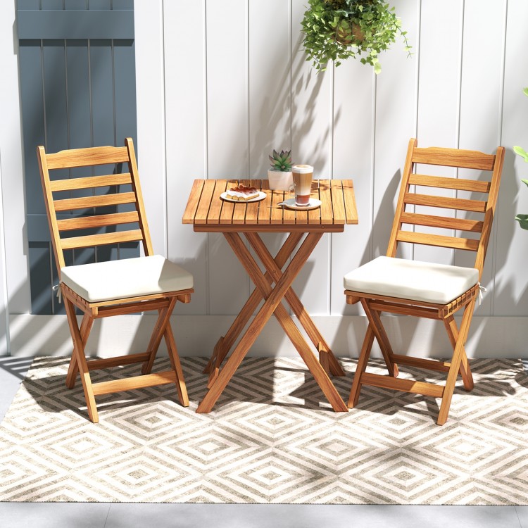 Folding chair table set with soft seat cushions in natural acacia wood, ideal for backyard or balcony relaxation.