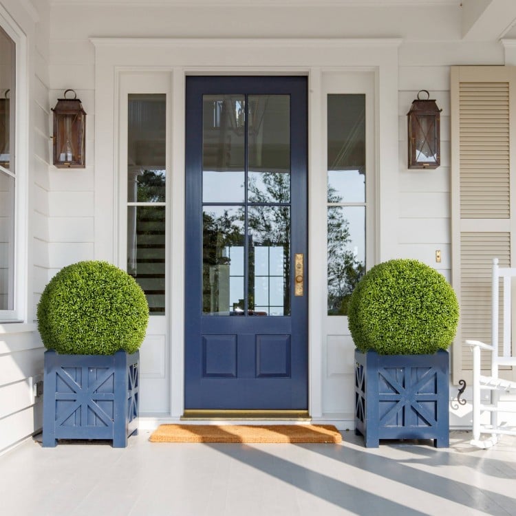 Two 20-inch artificial topiary spheres in blue planters, perfect for decorating patios, gardens, or front doors.
