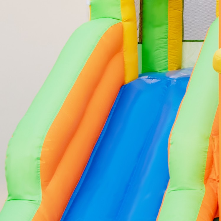 Colorful kids inflatable water slide featuring dual slides and a climbing wall, perfect for summer fun in the yard.
