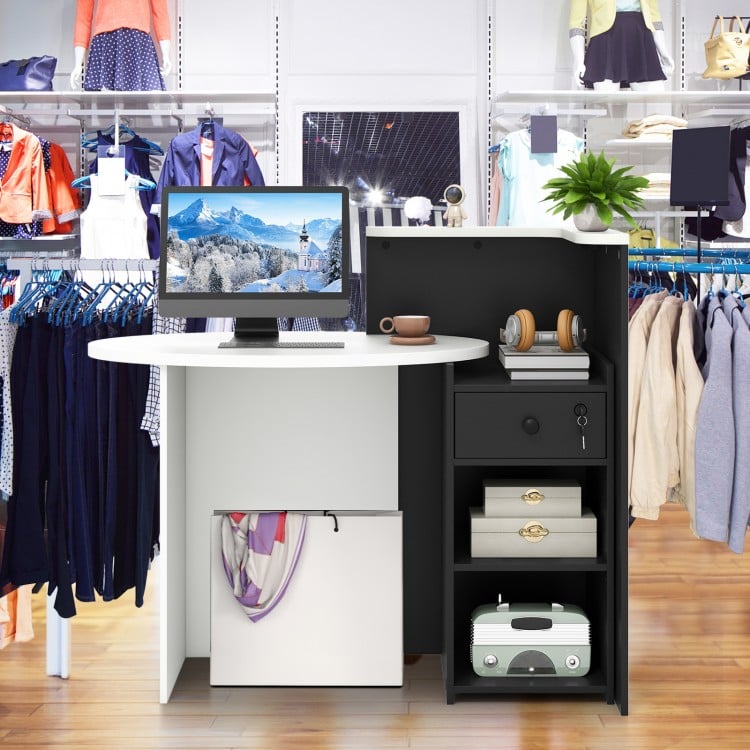 Front reception office desk in black and white with oval tabletop, open shelf, and lockable storage drawer for.