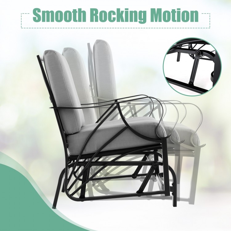 Patio glider rocking chair with gray thick cushion and curved armrests, designed for comfortable outdoor relaxation.