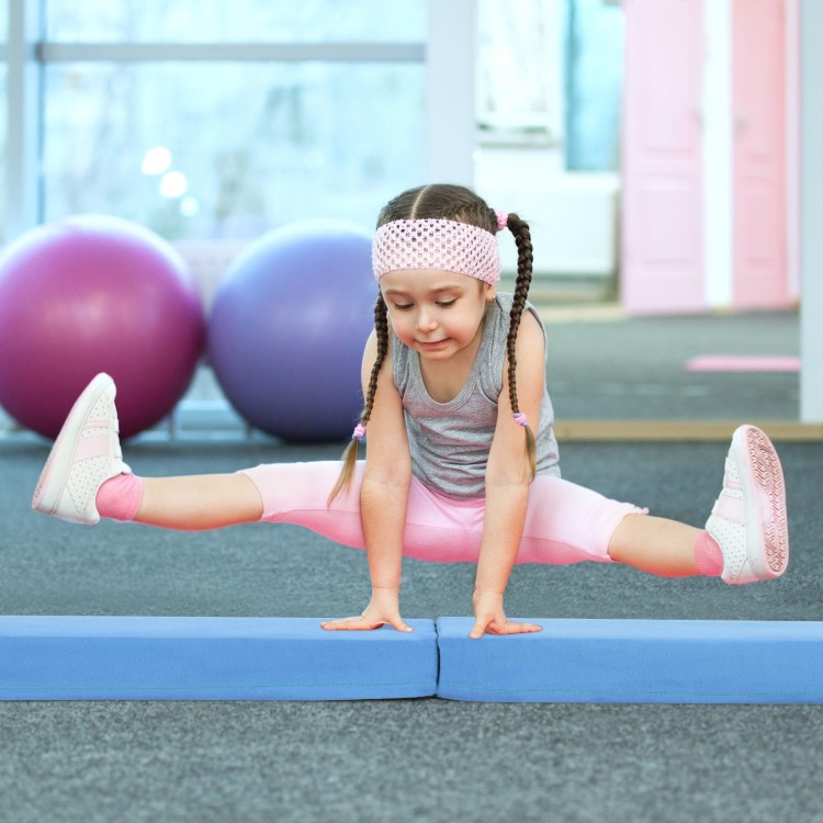 Child performing a split on a 7 FT folding balance beam with a suede cover, ideal for home gymnastics training.