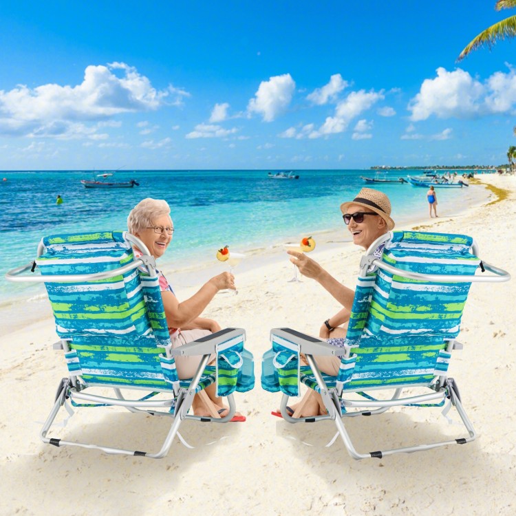 Two foldable beach chairs in green with cup holders, set on the beach, perfect for relaxation and convenience.