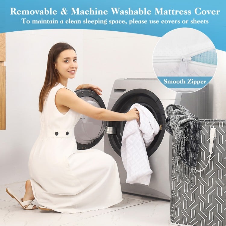 Woman placing a removable, machine washable mattress cover into a washing machine for easy maintenance.