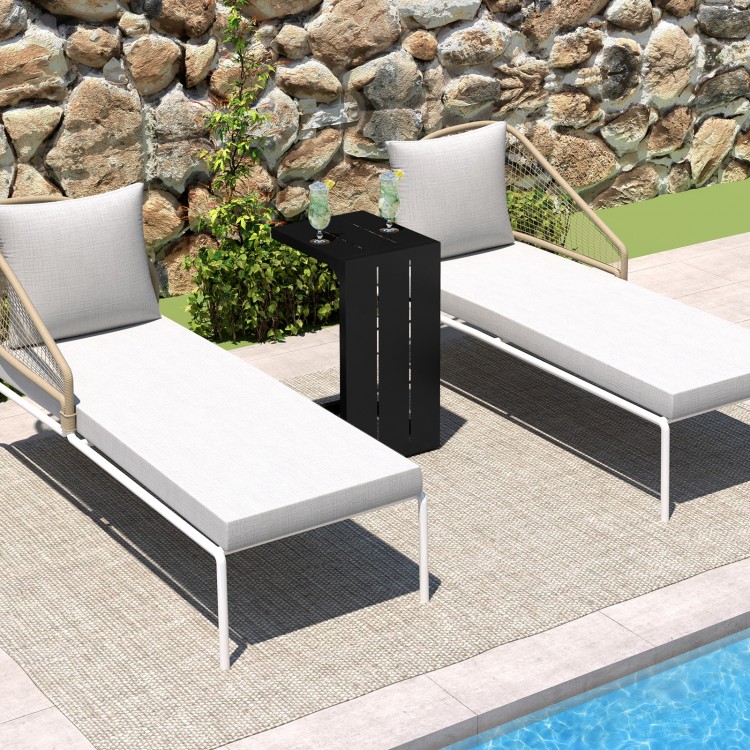 C-shaped end table in black with adjustable foot pads, ideal for indoor or outdoor use, shown beside lounge chairs.