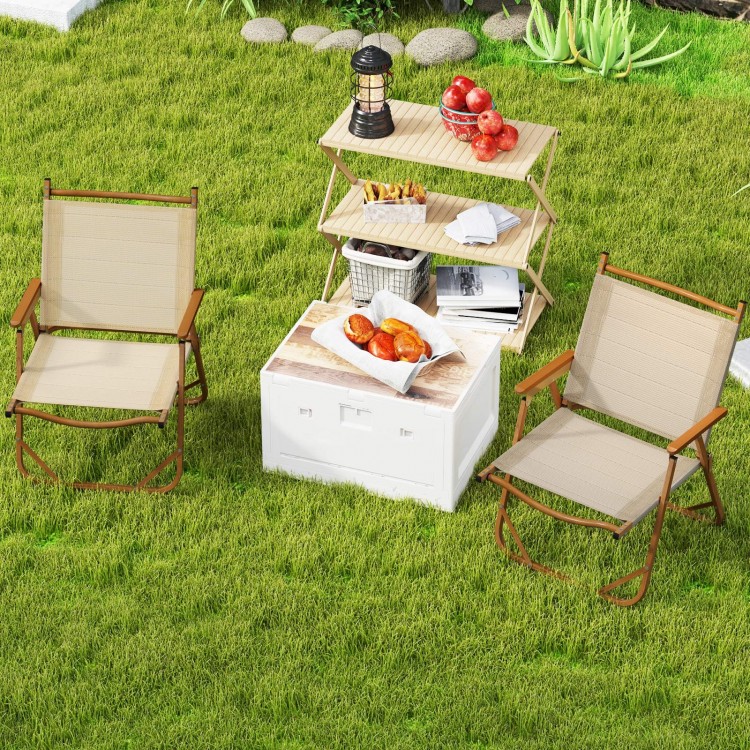 Two lightweight beige folding camp chairs with cozy armrests, set in a grassy area, ideal for outdoor relaxation.