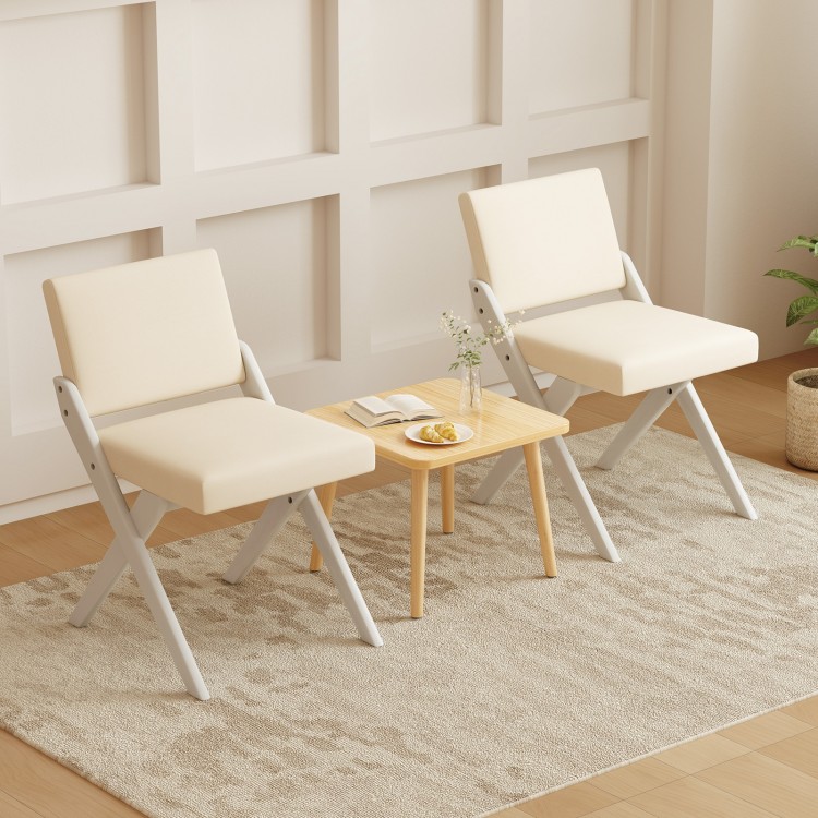Two white padded dining chairs with rubber wood frames and a small wooden table, perfect for modern farmhouse.