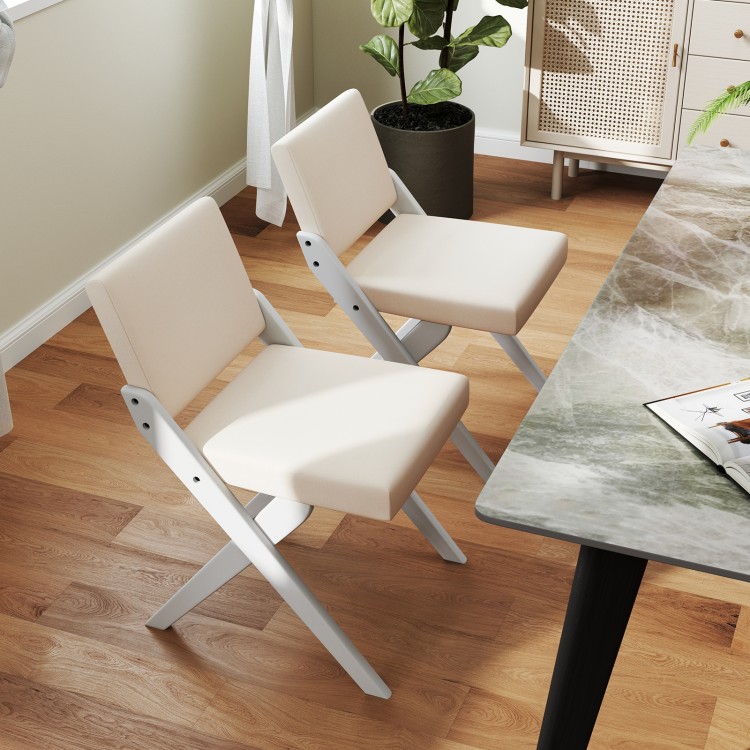 Two white wooden dining chairs with padded cushions, featuring rubber wood frames, ideal for modern farmhouse.