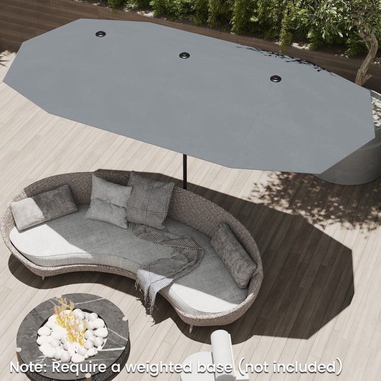 Double-sided 13 ft gray patio umbrella with crank handle, providing ample shade for outdoor lounging on the patio.
